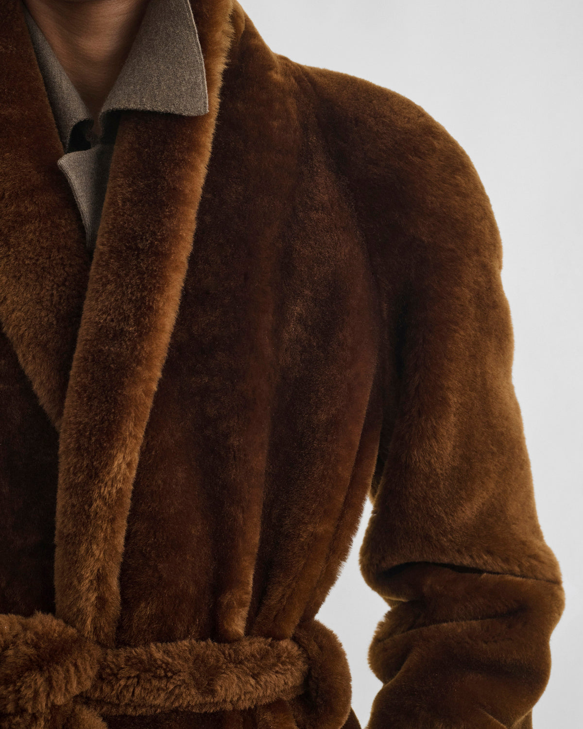 Front shoulder view of model wearing BELTED ROBE JACKET in burnt orange shearling